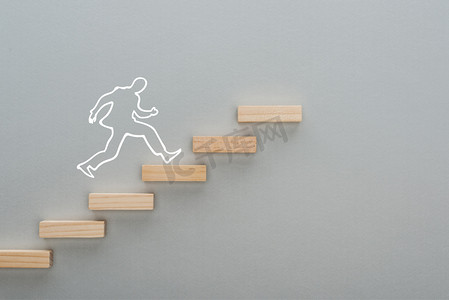 立体方块白摄影照片_在灰色背景、商业概念上象征职业阶梯的木制方块上跑步的人的头像