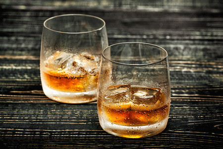 威士忌加冰在黑色的木背景，选择性焦点