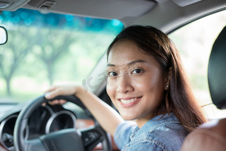 美丽的亚洲女人笑着欣赏着开车上路