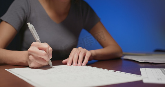 学习灯摄影照片_女人在办公桌写字特写