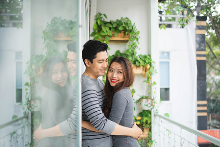 热恋中共享真正的感情和幸福，在阳台上拥抱的情侣