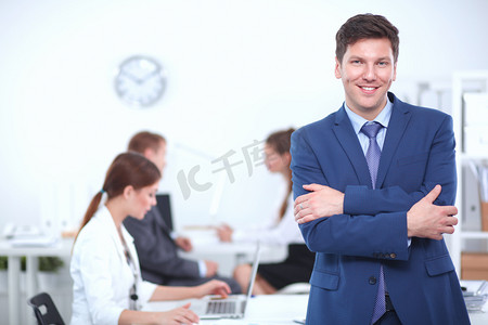 成功的业务人站在一起他在背景在办事处工作人员