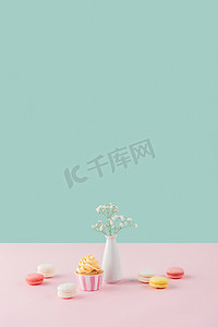 蛋糕和甜马卡龙在柔和的背景与花在花瓶 