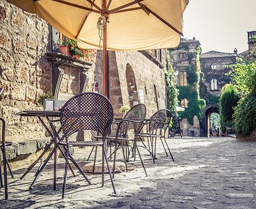 黄色的椅子摄影照片_在旧的街道，在欧洲与复古怀旧 Instagram 风格咖啡厅