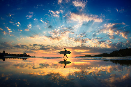 Sun surfer walking across the sea shore