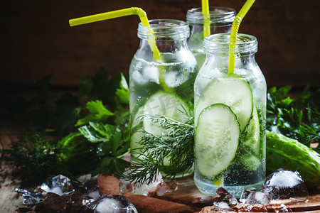 refreshing摄影照片_Refreshing cold drink of cucumber and herbs in glass bottles