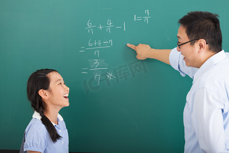 数学教材小棒摄影照片_老师在教室里讨论的小女孩