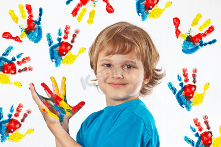 微笑的男孩用彩绘手手的背景上打印