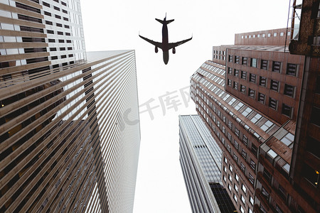 底部的摩天大楼和晴朗的天空与飞机在纽约市, 美国