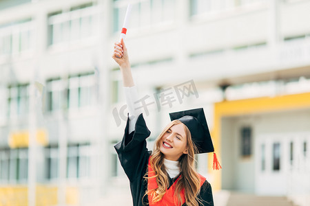 开心高考女孩摄影照片_快乐而又漂亮的研究生，拥有大学学位，表现出一种胜利的姿态，并且很快乐。毕业典礼的概念