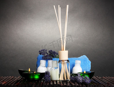 空气清新剂、 瓶、 毛巾和竹凉席上的灰色背景上蜡烛