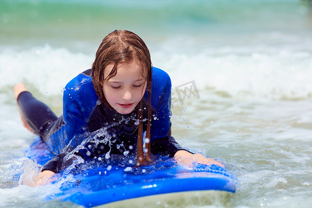 冲浪课程, 十几岁的女孩学会冲浪在一个温暖的冲浪服装
