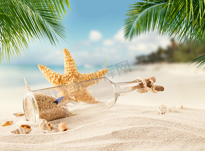 休假摄影照片_瓶与海星的热带沙滩