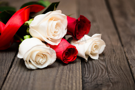 浪漫花朵装饰摄影照片_Red and white roses on a dark wooden background. Women' s day, V