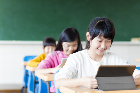 social摄影照片_ teenage girls student watching the tablet in classroom