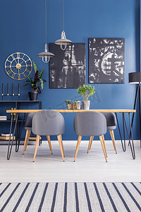 现代餐厅家具在一个充满活力的开放空间内部与海军蓝墙和时尚的装饰