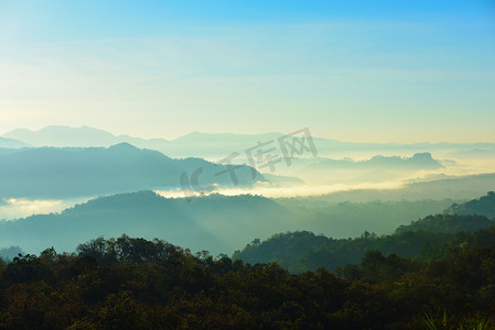 美丽的天空和金色的云彩。日出前的群山。清晨。太阳从山顶升起.