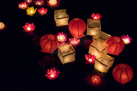 烟花蜡烛摄影照片_在夜间浮在水面上的纸灯笼