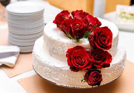 红玫瑰蛋糕摄影照片_婚礼蛋糕装饰着红玫瑰