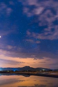 星空映照在水面上, 山顶上有一些云