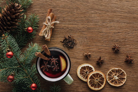 新年纹理摄影照片_在木制桌面, 圣诞节概念的热葡萄酒, 干桔子和杉木树枝的小玩意的顶部视图