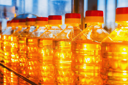 瓶身包装标签摄影照片_瓶中的油。工业生产葵花籽油。输送