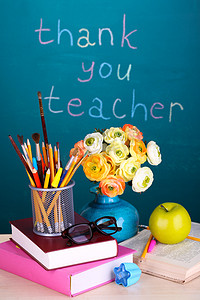 学校用品和题字谢谢老师的黑板背景上的花朵