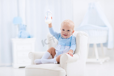 Baby boy with bottle drinking milk or formula