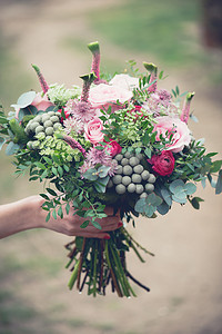 婚礼花束特写镜头，美丽温柔婚礼花束的混合花和新娘的手