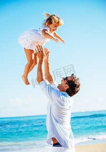 父亲和女儿一起在沙滩上玩 