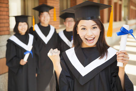 certificate摄影照片_happy college graduate holding diploma  and make a fist