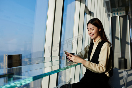 拍视频摄影照片_微笑的时髦女孩正在看手机上的搞笑视频