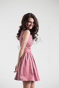 Young brunette lady in color dress. Fashion portrait in studio. 