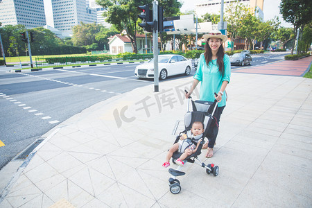 婴儿小推车摄影照片_婴儿在婴儿小推车在街头的人行道上