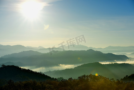 美丽的天空和金色的云彩。日出前的群山。清晨。太阳从山顶升起.