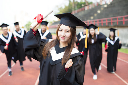 bachelor摄影照片_happy graduation students with diplomas outdoors