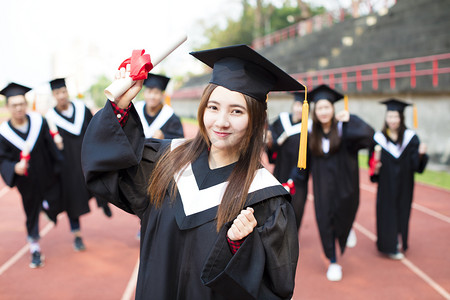 happy graduation students with diplomas outdoors