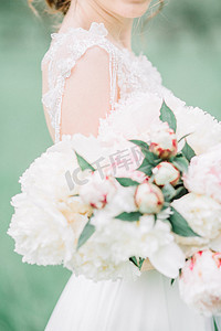 美丽婚礼花束粉红色和白色牡丹花在新娘的手中.