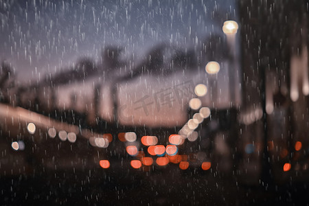 秋天雨天摄影照片_雨中的城市交通车辆，夜景城市，交通灯的流动，抽象的秋天背景