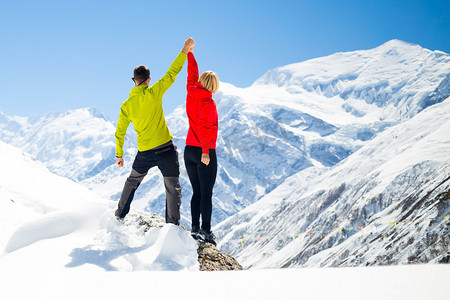 跨年徒步摄影照片_徒步旅行在冬天山上的男人和女人成功的夫妇
