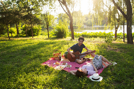 自然风景摄影照片_在公园里弹吉他的幸福情侣