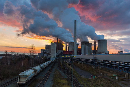 工业烟囱摄影照片_在日落时的褐煤电厂污染