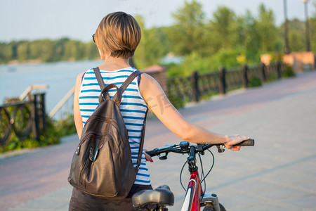 步行与自行车和背包里一名年轻女子在 promena 上