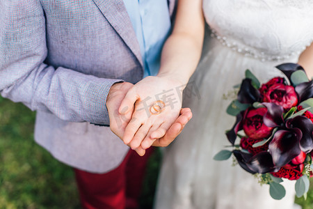 戒指的摄影照片_男性和女性手的特写举行美丽的结婚戒指