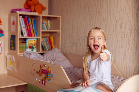 儿童节摄影照片_正在看书的女孩儿童节竖起大拇指