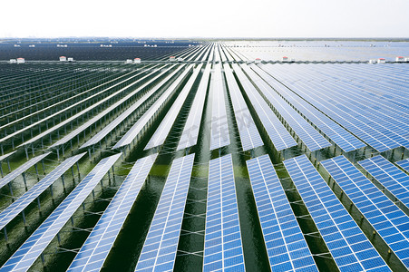 绿色生态摄影照片_空中看到的太阳能电池板。蓝色太阳能电池板。可再生能源光伏组件的背景