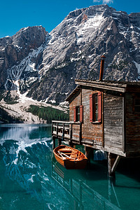 船在水中倒影摄影照片_在水中的山的倒影。Braies 湖 (Baraies) 在意大利阿尔卑斯山的惊人景色.