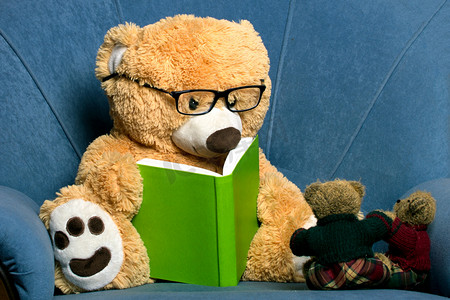 蓝色灵感摄影照片_戴着眼镜看书的泰迪熊