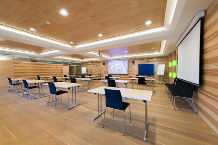 现代木制会议室的桌子椅子和投影仪屏幕