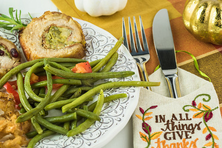 感恩节派对桌上的烤猪腰, 上面塞满了意大利香肠和花椰菜、绿豆.